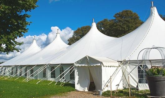 tall green portable restrooms assembled at a music festival, contributing to an organized and sanitary environment for guests in Simonton